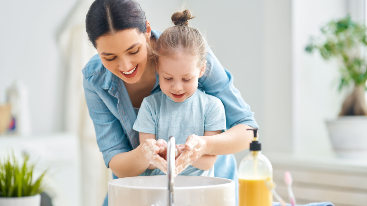 A little girl and her mother are washing their hands, protection against infections, flue and viruses