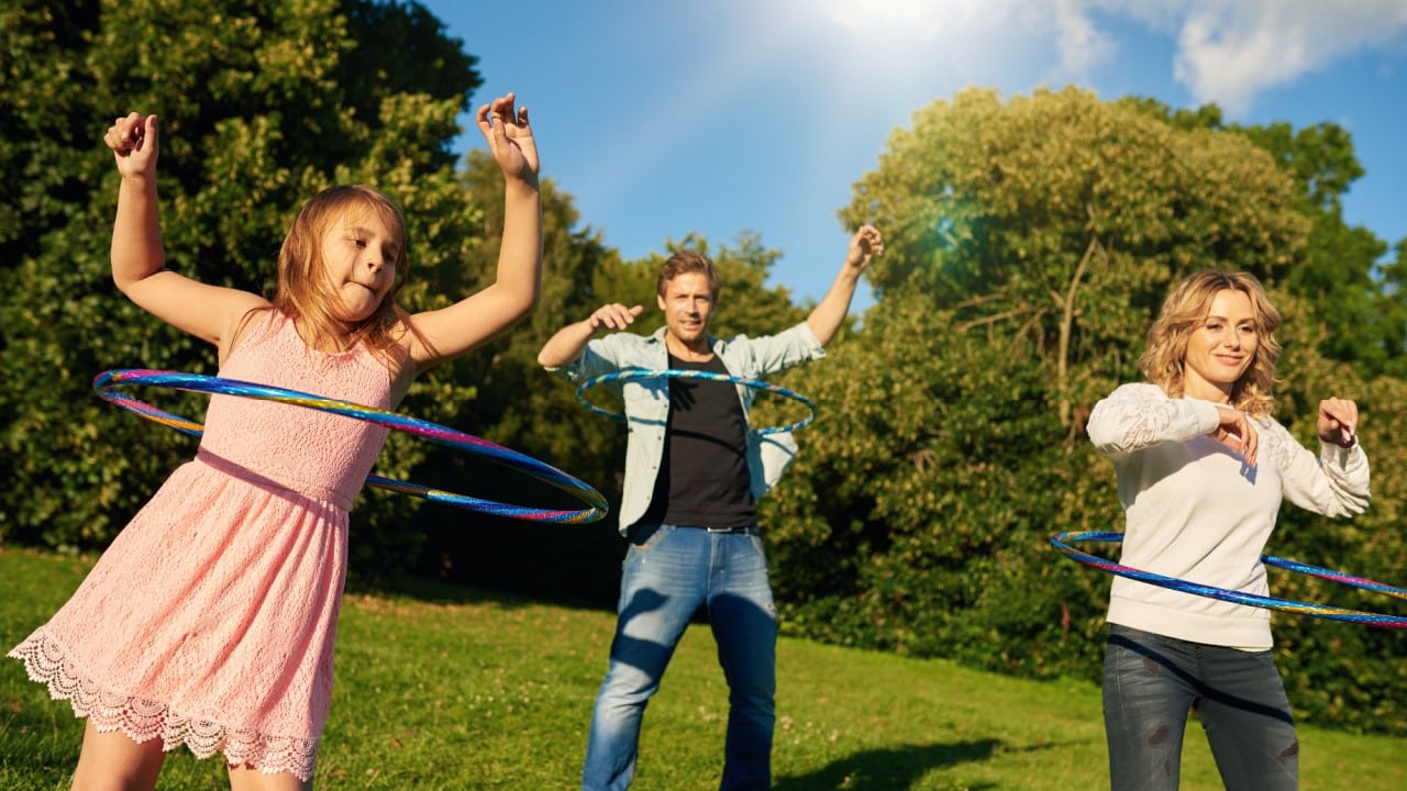 Fun loving family playing with hula hoops together outside