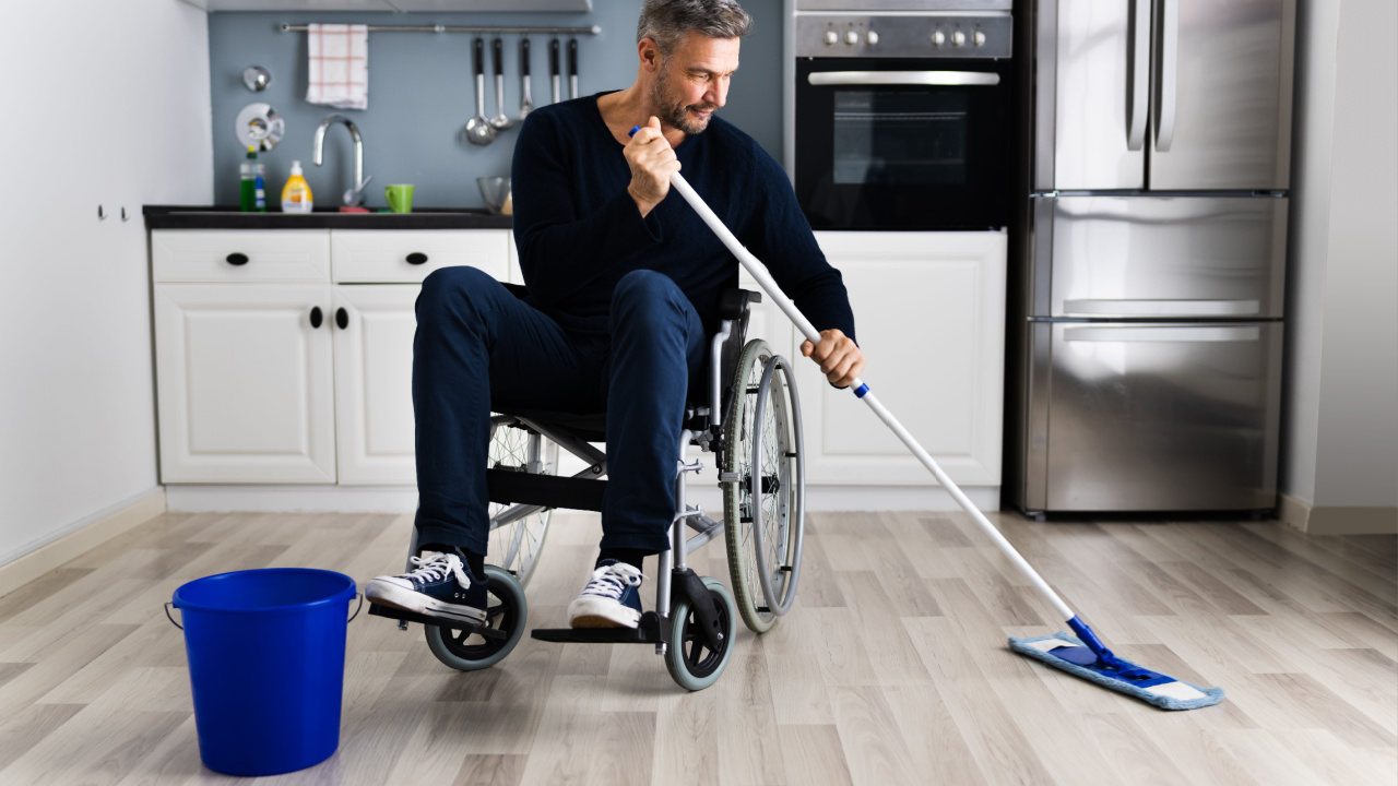 Handicapped disabled man cleaning kitchen floor using mop