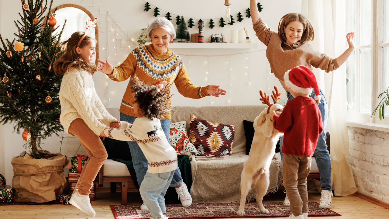 Happy family with three kids and golden retriever have fun on Christmas day at home, dancing to holiday, New Year music