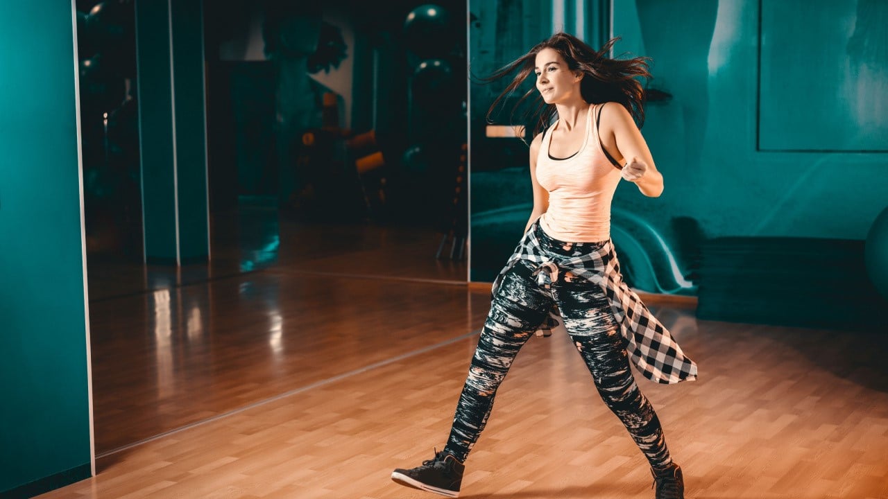 Young attractive brunette woman doing zumba dance workout, agility dance exercise