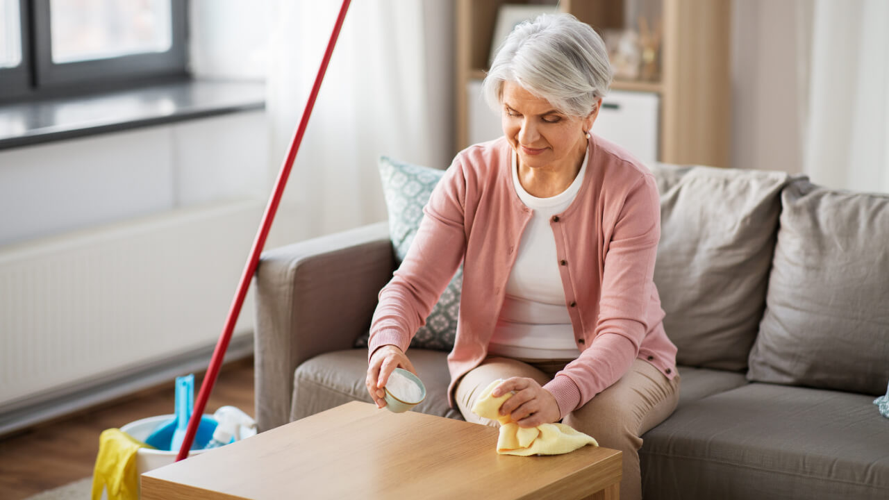 mature woman cleans table with baking soda and cloth bicarbonate soda cleaning deposit photos id 346764512