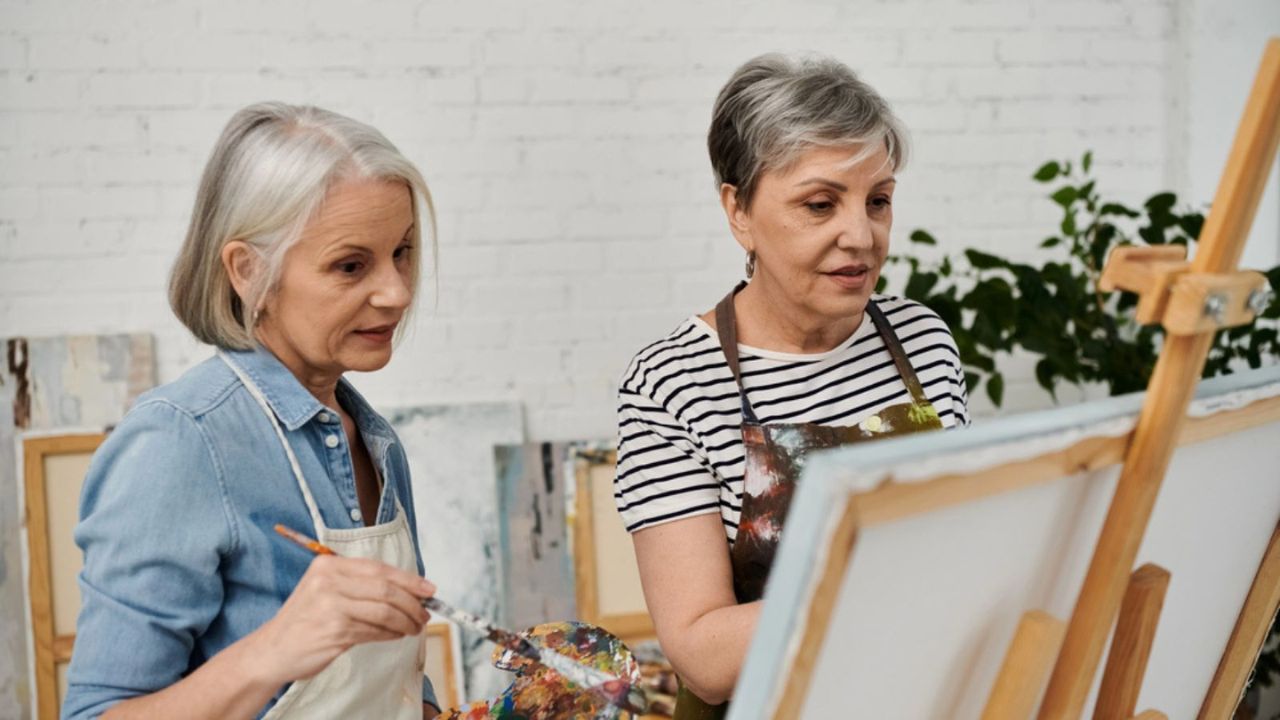 old retired elderly woman painting arts hobby